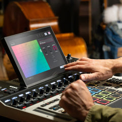 Person using a digital audio workstation with a colorful display in a studio setting.