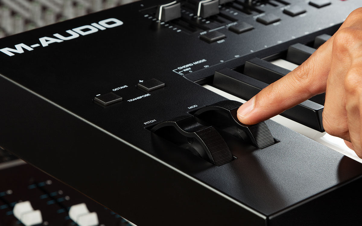 M-Audio keyboard controller with a hand pressing a key
