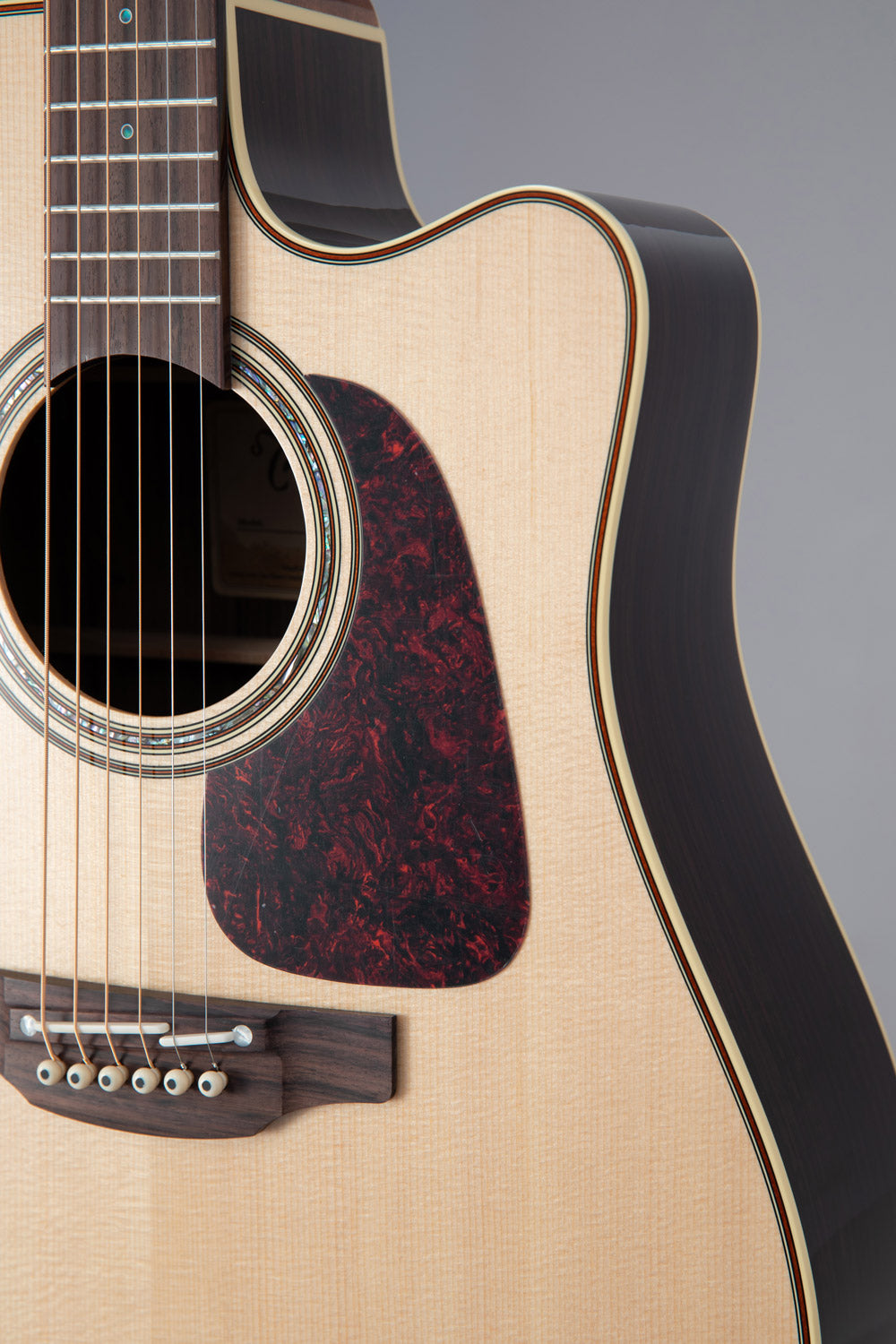 Close-up of an acoustic guitar with a focus on the soundhole and body.