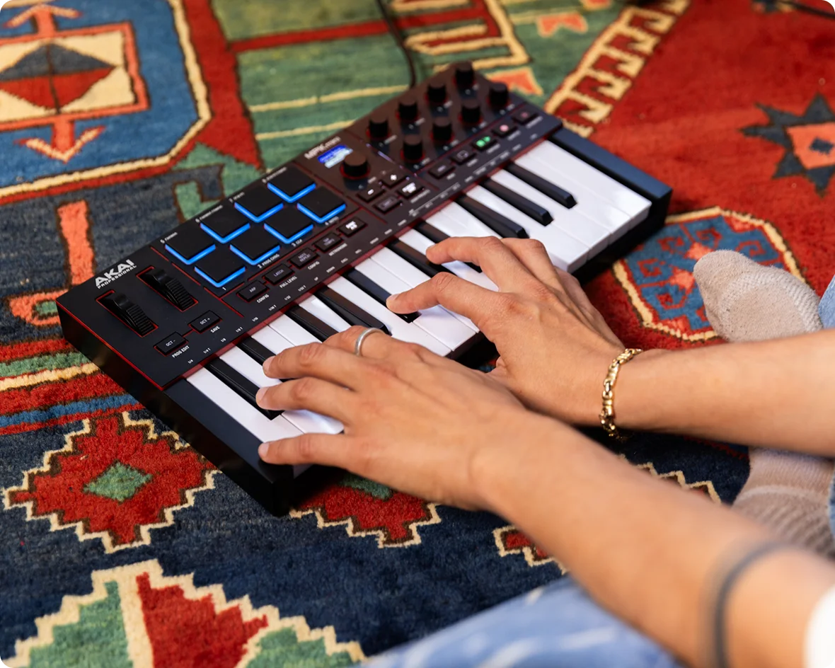 Person playing a keyboard on a colorful patterned rug